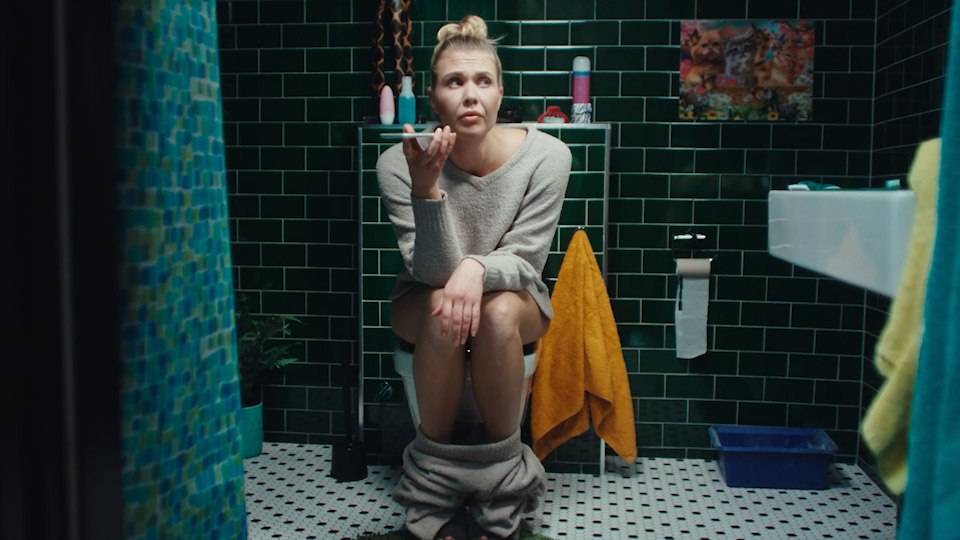 Commercial for PTS, girl on the toilet speaking on a phone.